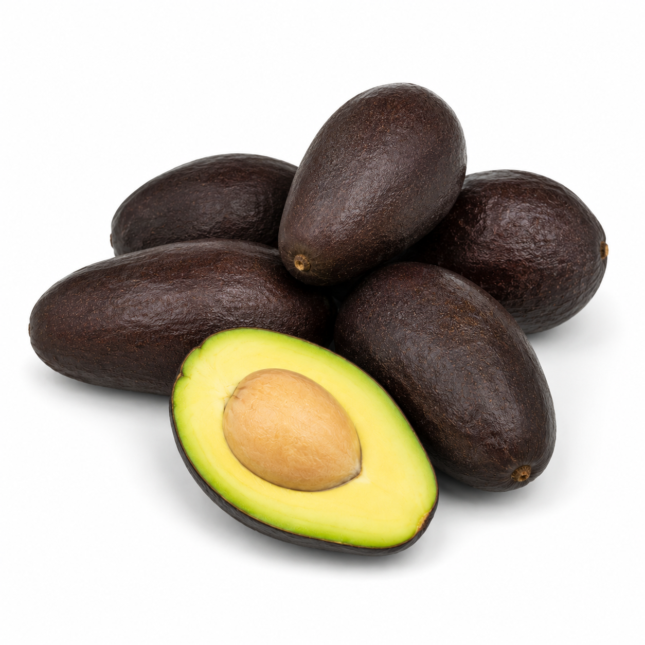 Small smooth black Mexicola avocados with one halved fruit showing yellow-green flesh and a large pale seed.